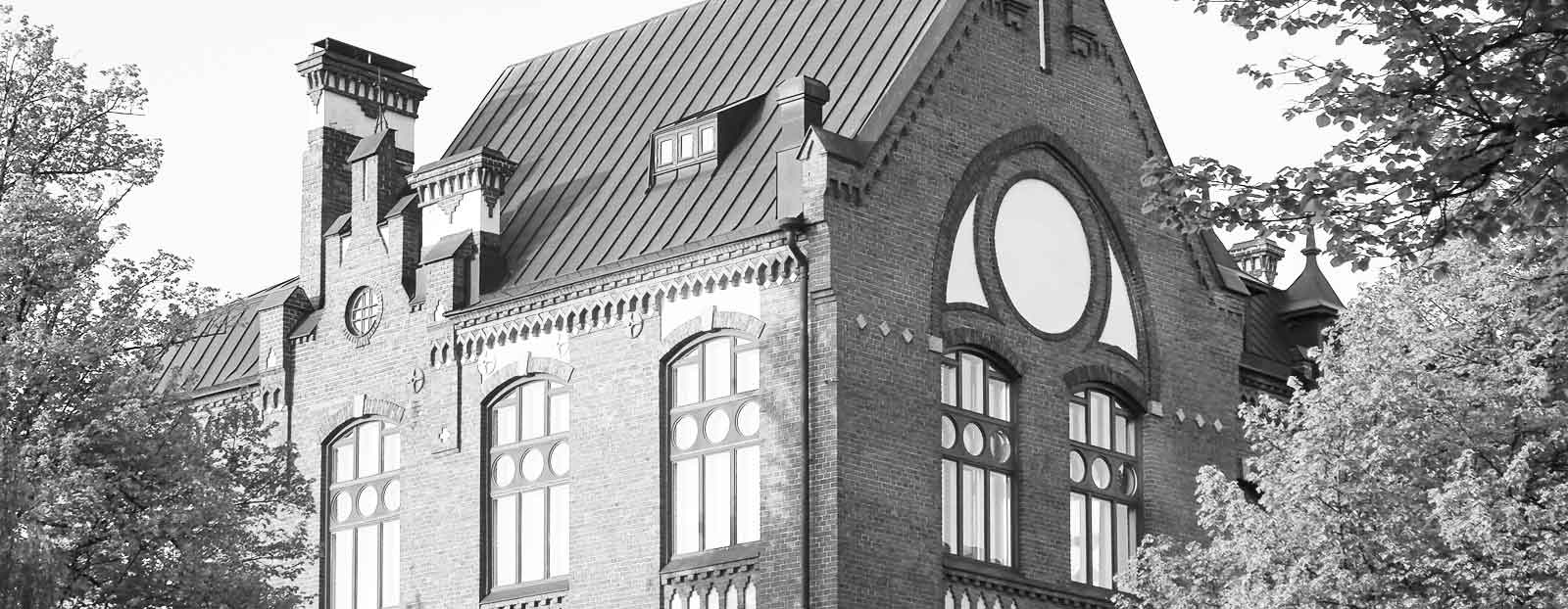 Mustavalkoinen kuva Lahden yhteiskoulun vanhasta koulurakennuksesta nimeltään Museo. Kuvattu rakennuksen profiili Kirkkokadulta katsottuna. 