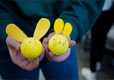 Keltaiset askarrellut pääsiäispuput oppilaan käsissä.