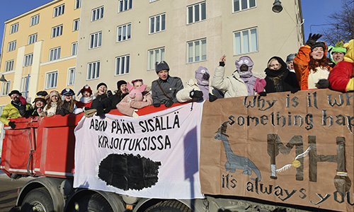Abiturientteja erilaisissa naamiaisasuissa penkkarirekan kyydissä.