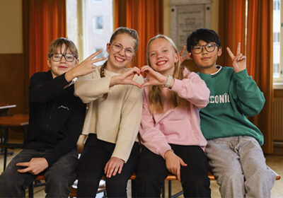 Hymyileviä Lahden yhteiskoulun oppilaita vanhassa juhlasalissa.