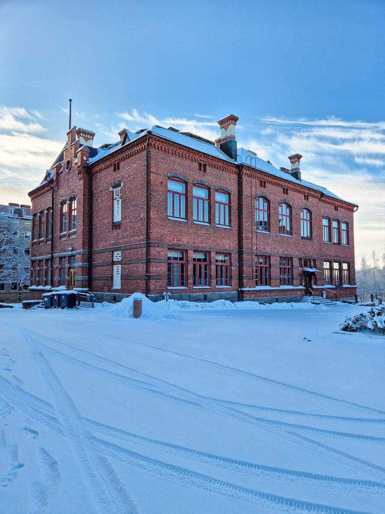 Lahden yhteiskoulun vanha koulurakennus aurinkoisena talvipäivänä kuvattuna sisäpihalta.