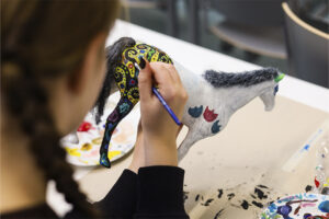 Nuori maalaa leikkihevosta koristeellisesti.