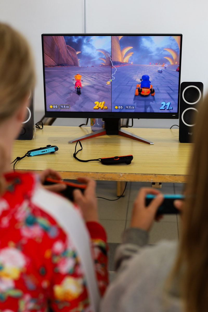 Kaksi nuorta pelaa konsolipeliä.